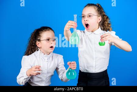 Kleine smarte Mädchen mit Testkolben. Zurück zur Schule. Schulkindwissenschaftler, die Naturwissenschaften studieren. Biologieausbildung. Kinder studieren Chemielabor, Entdeckung. Entdeckungskonzept. Neues Element entdecken. Stockfoto