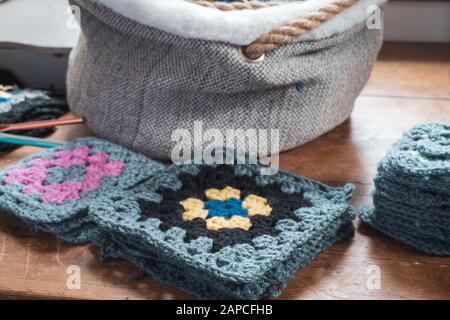 Handgefertigte Häkelgrannenfelder auf Holztisch. Stockfoto