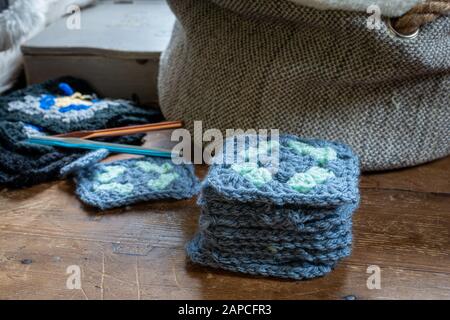 Handgefertigte Häkelgrannenfelder auf Holztisch. Stockfoto