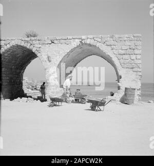 Israel 1964-1965: Caesarea, Archäologische Beschreibung: Aktivitäten in einem alten Gebäude Anmerkung: Caesarea ist ein Dorf und ein archäologischer Park in Israel, der im Bezirk Haifa liegt. Sie liegt etwa zwischen Tel Aviv und Haifa im Mittelmeer. Im Hinblick auf die Antike wird sie auch Caesarea Maritima genannt. Bei Caesarea wurden seit Jahrzehnten Ausgrabungen durchgeführt, und es gibt viel zu sehen. Es ist eine Touristenattraktion Datum: 1964 Ort: Caesarea, Israel Schlüsselwörter: Bögen, Bauarbeiter, Strukturen, Schubkarren Stockfoto