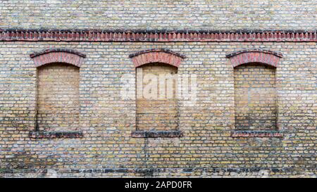 Drei Fenster eines alten Hauses sind oben gemauert Stockfoto