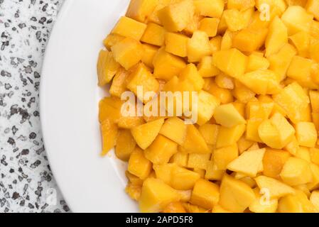 Mango-Stücke auf Platte. Eine Nahaufnahme. Gesunde natürliche Nahrung. Stücke saftiger gelber Früchte. Stockfoto