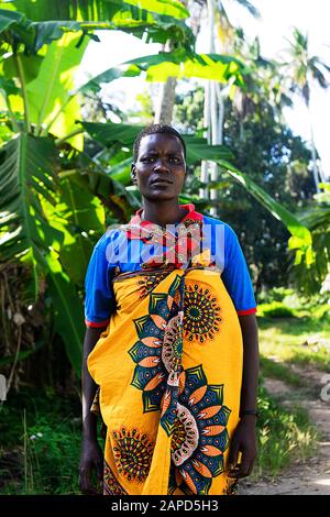 Tansania, Sansibar - 22. Januar 2020: Afrikanerin in einem hellen Kleid im tropischen Naturhintergrund. Reisekonzept. Stockfoto