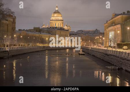 Dezember in Sankt Petersburg, Russland statt. Die Kathedrale von St. Isaac und der Fluss Moyka nach Schneefall in der Dunkelheit am frühen Morgen Stockfoto