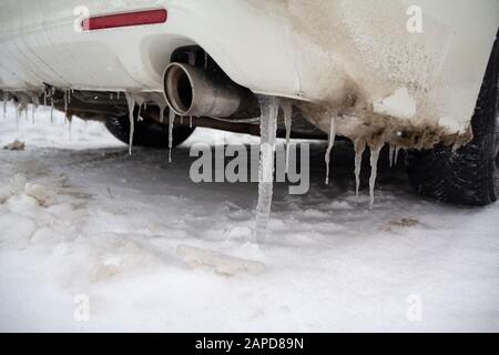 Viele große und scharfe Eiszapfen hängen am Auto. Winter Stockfoto