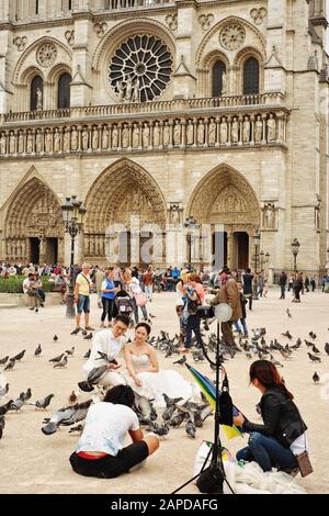 Straßenfoto eines Brautschusses mit Tauben, Statue von Karl dem große et ses Leudes an der Cathédrale Notre-Dame de Paris. Stockfoto