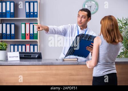 Die junge Patientin an der Rezeption im Krankenhaus Stockfoto