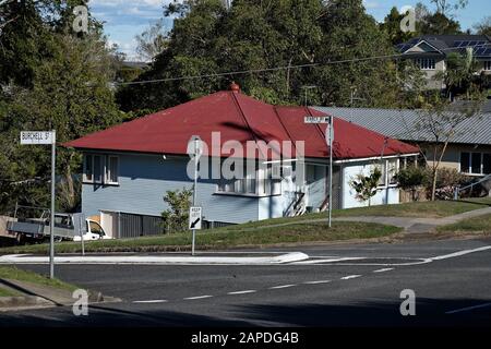 Unterhalb der Fahrbahn versteckt, ein Nahtwetterhaus der Nachkriegsarbeiter mit einem Wellblechdach, Carina, Brisbane Stockfoto