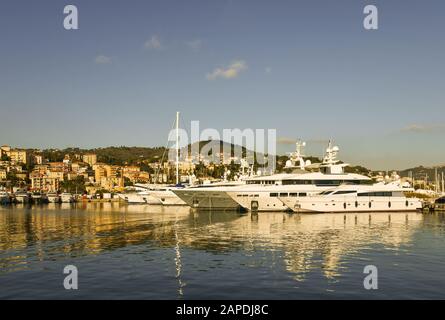 Blick auf den Touristenhafen von Porto Maurizio an der Blumenriviera mit Luxusyacht, die an einem sonnigen Tag an der Anlegestelle festgemacht wird, Imperia, Ligurien, Italien Stockfoto