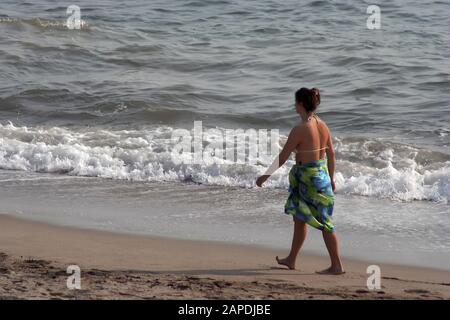 Frau zu Fuß am Strand Stockfoto