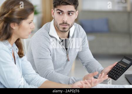 Mann, der Budget und Ausgaben aus der Anzahl der Rechner anzeigt Stockfoto