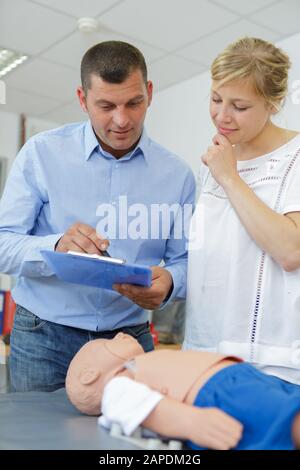 Frau auf dem First Aid Kurs mit einem Dummy in Säuglingsgröße Stockfoto