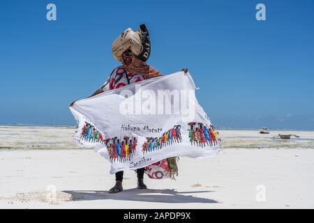 Sansibar, Tansania - 28. oktober 2019 : Afrikanerin verkauft Souvenirs und Kleidung für Touristen in der Nähe des Ozeans am Strand auf der Insel Sansibar, Tanz Stockfoto