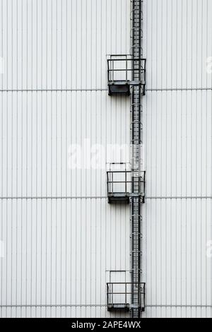 Vertikale Aufnahme eines hohen weißen Gebäudes mit einer Leiter Auf der Seite Stockfoto