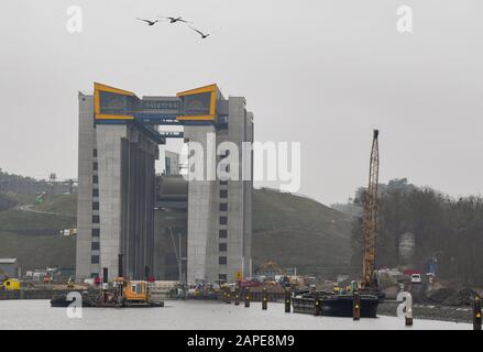 Niederfinow, Deutschland. Januar 2020. Schwäne fliegen über die Baustelle des neuen Schiffshebers. Der Probebetrieb für den neuen Schiffshebewerk in Niederfinow (Barnim) wurde verzögert und soll erst im Sommer starten. Die Wasserstraßen- und Schifffahrtsverwaltung des Bundes baut seit 2009 in Niederfinow einen neuen Schiffshebezug, um das alte technische Denkmal an der Oder-Havel-Wasserstraße zu ersetzen, das aus dem Jahr 1934 stammt und als Nadelöhr auf der Wasserstraße von Berlin zur Ostsee gilt. Credit: Patrick Pleul / dpa-Zentralbild / ZB / dpa / Alamy Live News Stockfoto