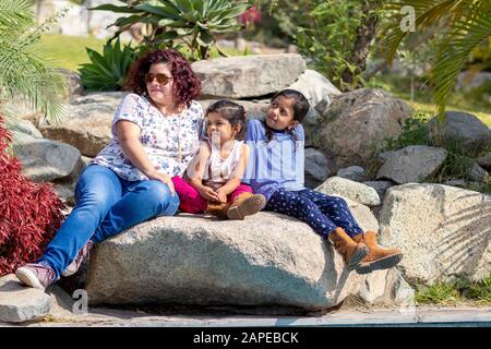 Niedliche Familie von Mutter und Töchtern im Garten Stockfoto