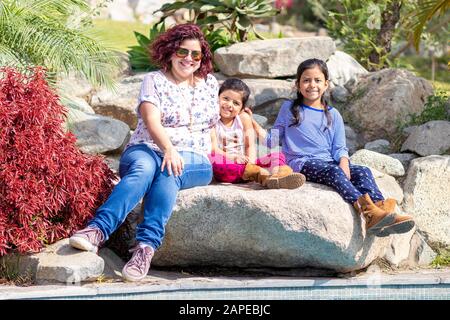 Niedliche Familie von Mutter und Töchtern im Garten Stockfoto