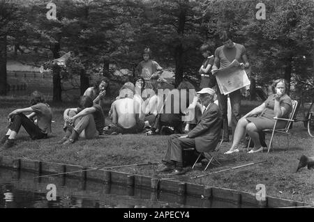 Erster heißer Sommertag Beschreibung: Älterer Fischer umgeben von Hippies im Vondelpark in Amsterdam Datum: 26. Juni 1972 Ort: Amsterdam, Noord-Holland, Vondelpark Schlüsselwörter: Angeln, Hippies, Jugend, Senioren, Parks, Freizeit Stockfoto