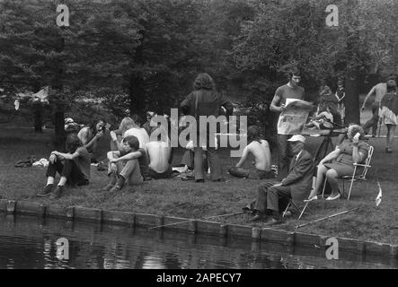 Erster heißer Sommertag Beschreibung: Älterer Fischer umgeben von Hippies im Vondelpark in Amsterdam Datum: 26. Juni 1972 Ort: Amsterdam, Noord-Holland, Vondelpark Schlüsselwörter: Angeln, Hippies, Jugend, Senioren, Parks, Freizeit Stockfoto
