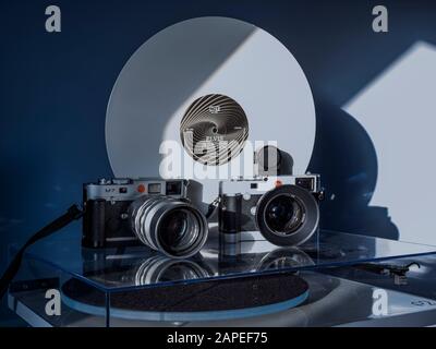 Zwei leica-m-Kameras auf einem Plattendrehtisch mit einer weißen vinyl-elvis-presley-schallplatte dahinter Stockfoto