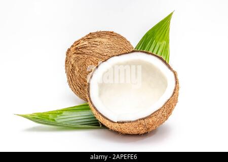 Kokosnuss Hälfte und Blätter auf weißem Hintergrund Stockfoto