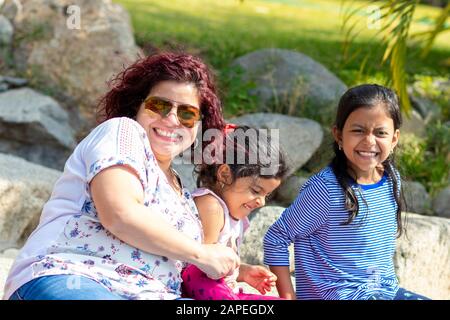 Niedliche Familie von Mutter und Töchtern im Garten Stockfoto