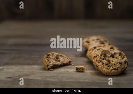 Klassische Schokoladenchip-Plätzchen vor Holzhintergrund. Stockfoto