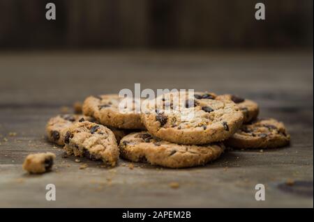 Klassische Schokoladenchip-Plätzchen vor Holzhintergrund. Stockfoto