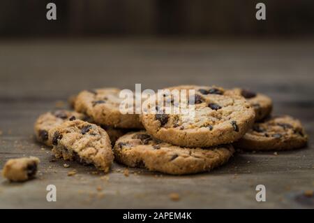 Klassische Schokoladenchip-Plätzchen vor Holzhintergrund. Stockfoto
