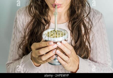 Junge Frau trinkt traditionellen argentinischen Yerba Mate Tee. Stockfoto