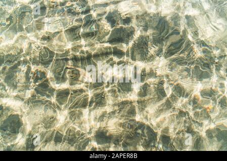 Transparente Wasseroberfläche und Sand auf dem Seeboden. Stockfoto