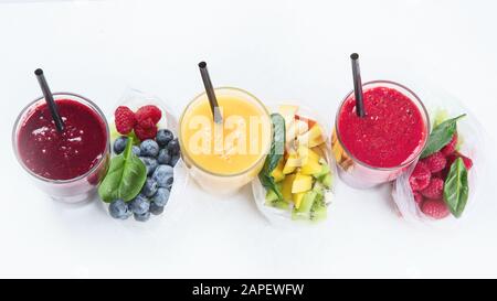 Htalthy frische Obst- und Gemüsesmoothies mit verschiedenen Zutaten in Packungen. Draufsicht mit Kopierbereich Stockfoto