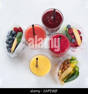 Htalthy frische Obst- und Gemüsesmoothies mit verschiedenen Zutaten in Packungen. Draufsicht Stockfoto