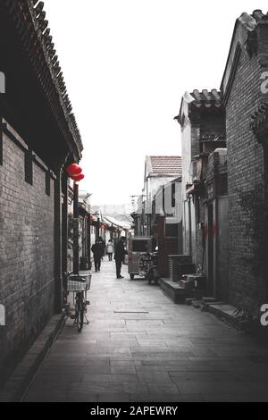 Dekorierte Straße/Hutong/kleine Gasse in Peking während des chinesischen Neujahrs, auch als Frühlingsfest bezeichnet. Mit Rikscha Stockfoto