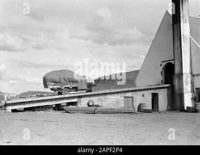 Island Beschreibung: Bauernhof in Korpúlfsstaðir. Ein LKW mit Heu betritt die Heuscheune über eine Steigung Datum: 1934 Standort: Island, Korpúlfsstaðir Schlüsselwörter: Arbeiter, Heu, Heu, Tore, Lastwagen Stockfoto