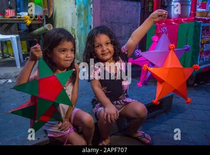 Ein philippinisches Mädchen, das eine Laterne auf einem Weihnachtsmarkt in Las Pinas Stadt, Manila auf den Philippinen hält Stockfoto