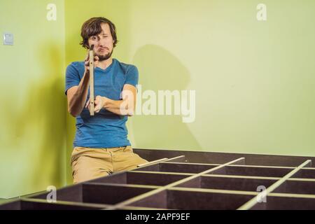 Frustriert Mann Zusammenstellung Selbstmontage Möbel Stockfoto