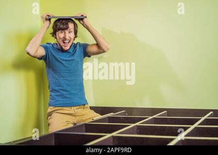 Frustriert Mann Zusammenstellung Selbstmontage Möbel Stockfoto