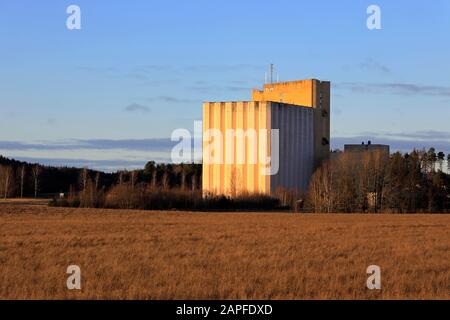 Pernio Granary, Kornelevator von Suomen Viljava Oy, auf Feldern in goldenem Licht des Sonnenuntergangs zu sehen. Dieses Wahrzeichen in Salo befindet sich im Besitz des Staates Finnland. Stockfoto