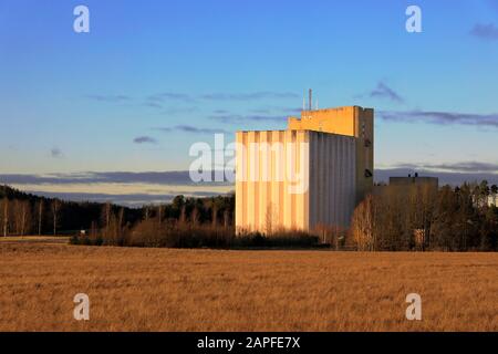 Pernio Granary, Kornelevator von Suomen Viljava Oy, auf Feldern in goldenem Licht des Sonnenuntergangs zu sehen. Dieses Wahrzeichen in Salo befindet sich im Besitz des Staates Finnland. Stockfoto