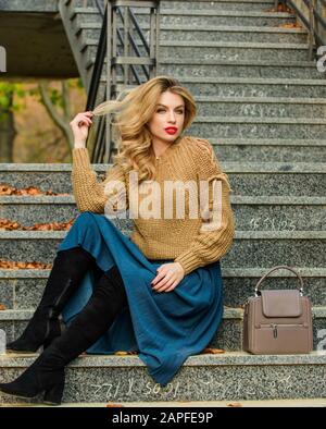 Warte auf ihn, weibliche Schönheit. Modelart: Mädchen in Wellrock und Pullover. Plissierter Trend. Legere Studenten. Herbstsaison. Herbstfrau lockige Haare im Freien. Mädchen lange blonde Haartreppen. Stockfoto