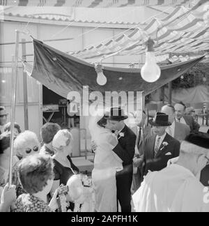 Israel 1964-1965: Tel Aviv, Heiratsbeschreibung: Brautpaar steht unter der Choepa, während sich die Brautpaar gegenseitig umarmen Anmerkung: Brautpaar (Kallah und Chatan) stehen schließlich unter einer Choepa (Hochzeitsbaldachin) zusammen, nachdem die Frau die Choepa und ihren Bräutigam sieben Mal umkreist hatte. Die Choepa wird normalerweise außerhalb des Hotels aufgestellt und ist repräsentativ für die Gastfreundschaft der Neuvermählten (sog. 'offenes Haus') Datum: 1964 Ort: Israel, Tel Aviv Schlüsselwörter: Baldachin, brautstrauß, brautpaare, Partybeleuchtung, Bademäntel, Kopfbedeckung, Hochzeitsgäste, Hochzeitsfeierlichkeiten, jüdische Religion, Rabbis, V. Stockfoto