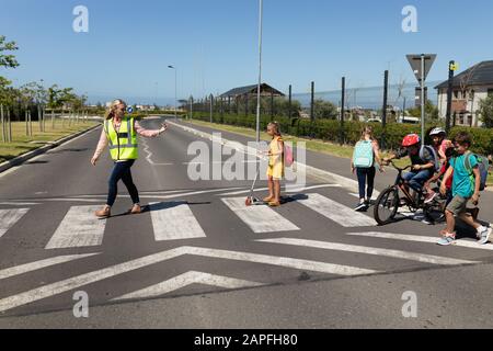 Frau, die eine gut sichtbare Weste auf einer Fußgängerüberführung trägt Stockfoto