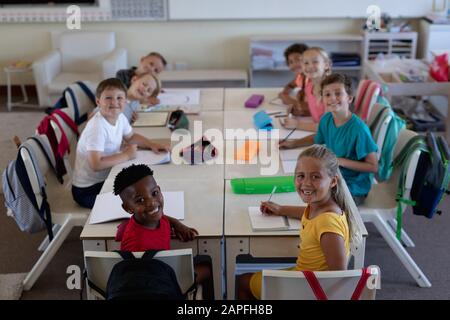 Gruppe von Schulkindern, die in einem Schulunterricht arbeiten Stockfoto