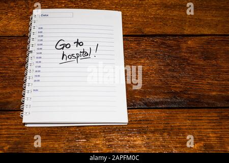 Gehen Sie zum Krankenhaus, Handschriftertext auf der Seite der Büroagenda. Kopierbereich. Stockfoto