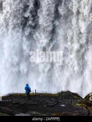 Einsamer Tourist in der Nähe des Gorgeus Dettifoss Wasserfalls - der mächtigste Wasserfall Europas. Jokulsargljufur National Park, Island. Landschaftsfotografie Stockfoto
