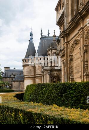 Waddesdon Manor, Hängetürme, steile Roofleine und gotisches Architekturgefühl. Abgerundete, gestutzte Hecken im Vordergrund. Heim von Ferdinand Rothschild. Stockfoto