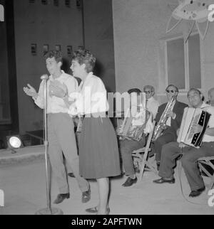 Israel 1964-1965: Tel Aviv, Feier des Unabhängigkeitstages Beschreibung: Kabarett und Musiker auf der Straße Anmerkung: Die Einwohner feiern den Unabhängigkeitstag des Staates Israel, sie tanzen auf der Straße, sie verkaufen und kaufen Partyzubehör und sie essen festliche Vorspeisen Datum: 1964 Ort: Israel, Tel Aviv Schlüsselwörter: Akkordeons, Kabarett, Mikrofon, Musik, Nachtbilder, nationale Feiertage, Straßenbilder Stockfoto