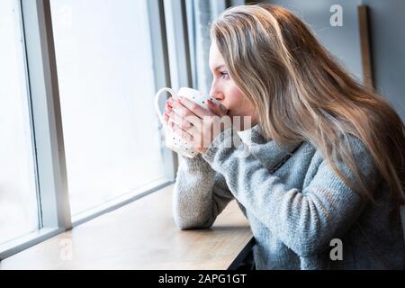 Frau, die Tee im Café hat Stockfoto