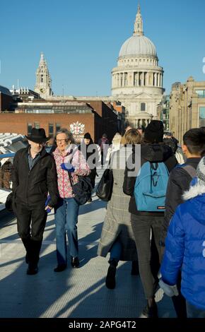 Die Menschen gehen über die Millennium Bridge mit der St. Paul's Kathedrale im Hintergrund an der Themse in London, England, Großbritannien Stockfoto